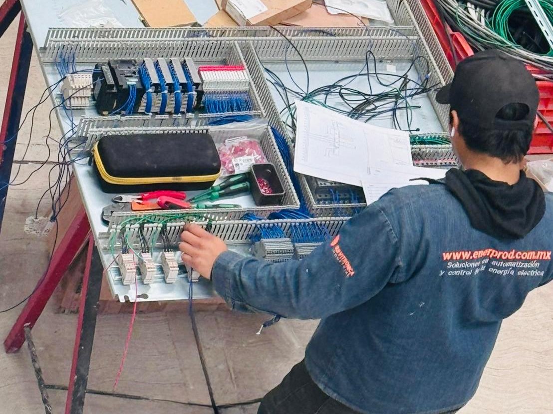 Técnico armando un tablero de control en taller