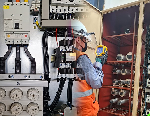 Técnico midiendo con cámara termográfica un banco de capacitores en operación